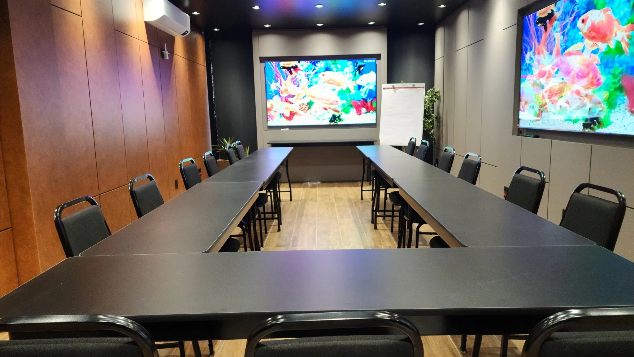 Sala montada em U para reunião com duas telas no Espaço Convivium Vila Olímpia